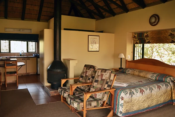 Comfortable lounge with fireplace in a 2-bed Garden View Chalet at Giant’s Castle