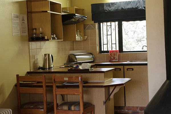 Fully equipped kitchen and dining area inside the 2-bed Garden View Chalet at Giant’s Castle